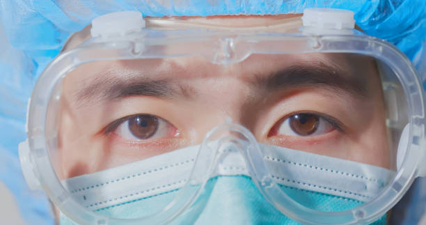 Doctor in hospital wearing anti-fog safety goggles and mask as part of PPE infection control equipment Doctor in hospital wearing anti-fog safety goggles and mask as part of PPE infection control equipment